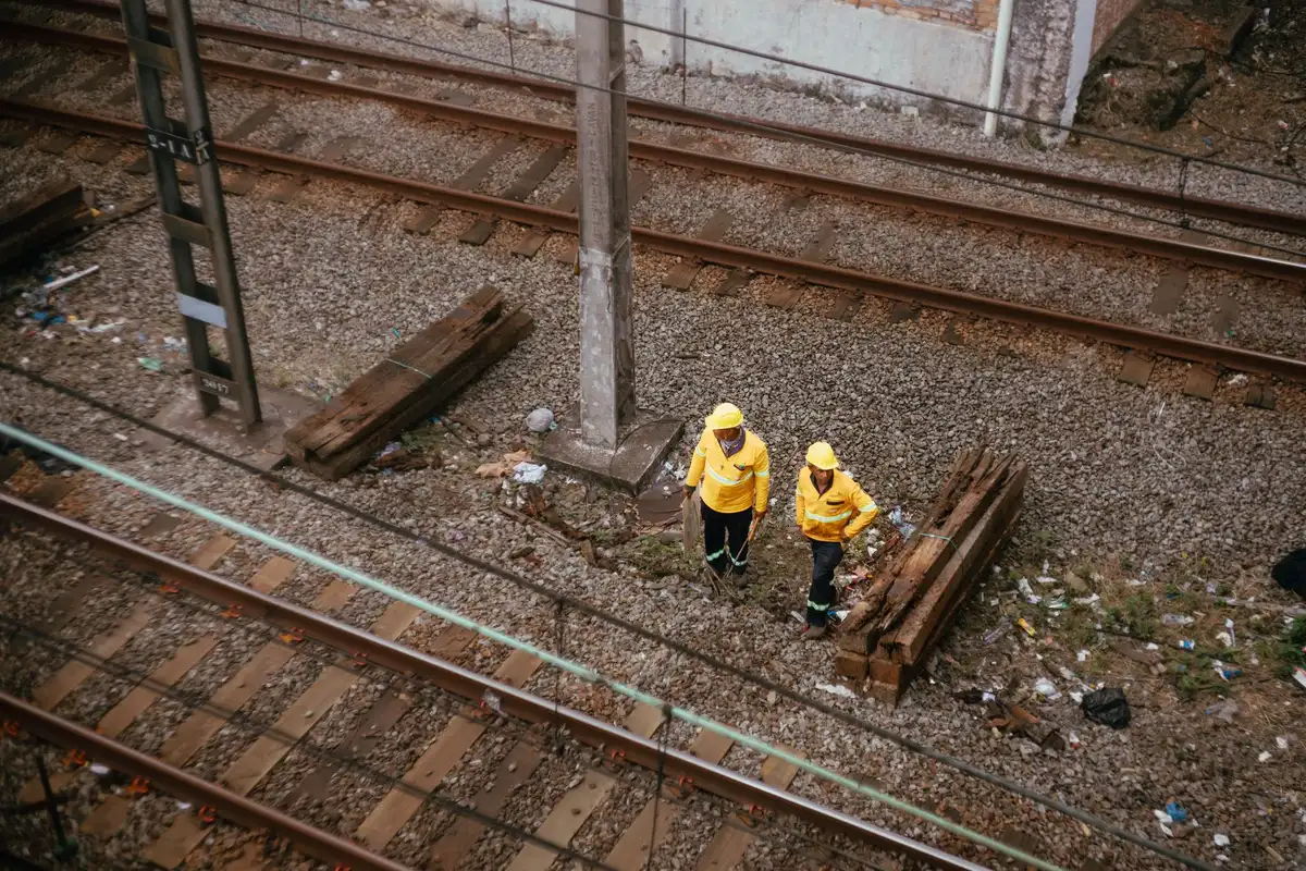 Inspector revisando estado de vías ferroviarias con equipamiento de seguridad