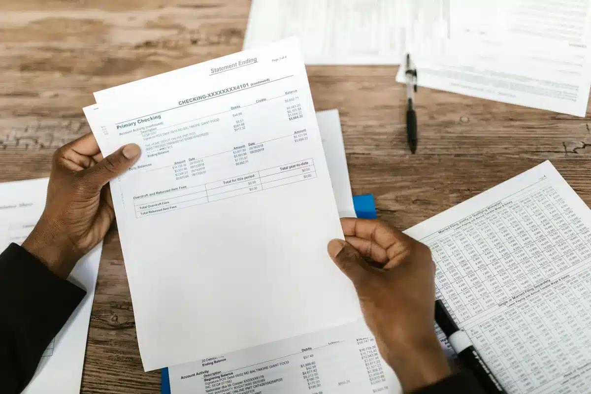 Documentos de solicitud de ayudas económicas y formularios de renta familiar sobre una mesa
