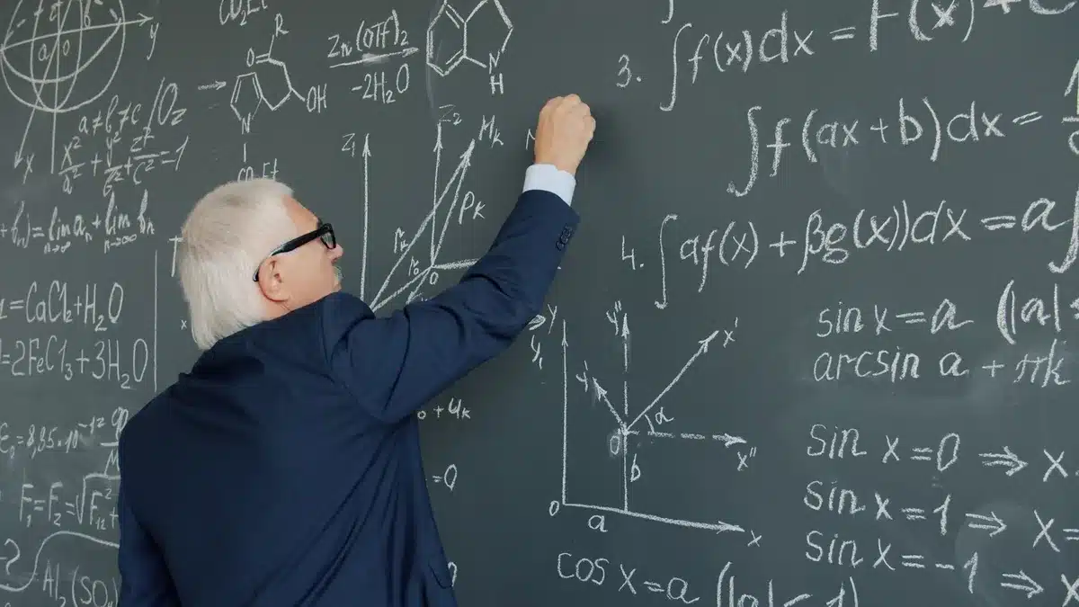 Dos docentes imparten una clase de Matemáticas a un grupo de estudiantes en un aula.