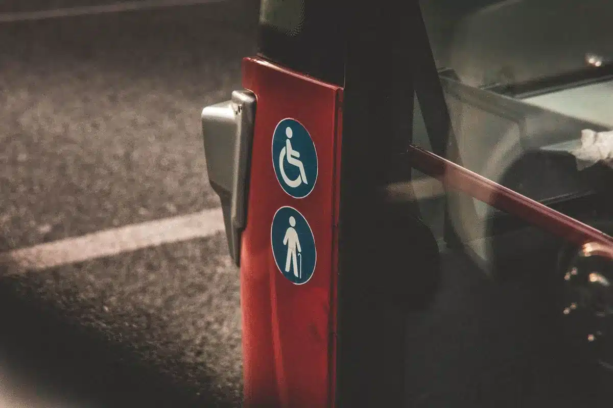 Persona con discapacidad accediendo a transporte público con asistencia