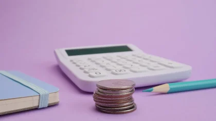 Materiales escolares y presupuesto familiar en una mesa con documentos de ayuda