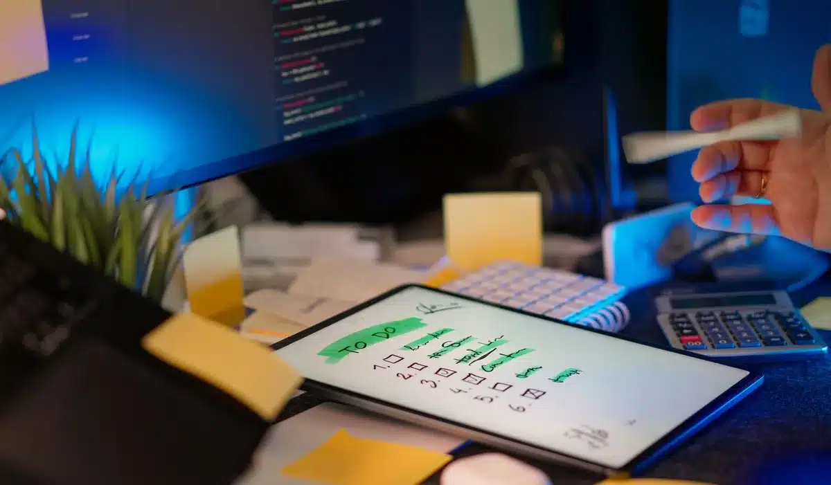 Persona evaluando opciones de software en pantalla con lista de criterios de selección