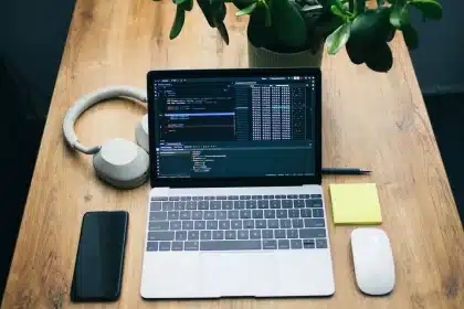 Escritorio con computadora mostrando interfaz de facturación electrónica, documentos y calculadora