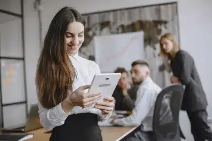 Manos sosteniendo una tableta con facturas digitales y gráficos de pagos en pantalla