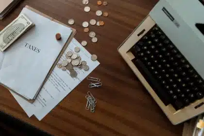 Manos de un autónomo revisando documentos fiscales y cuotas de la Seguridad Social sobre un escritorio con calculadora