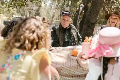 Abuelos y nietos conversando alrededor de una mesa en un ambiente familiar cálido