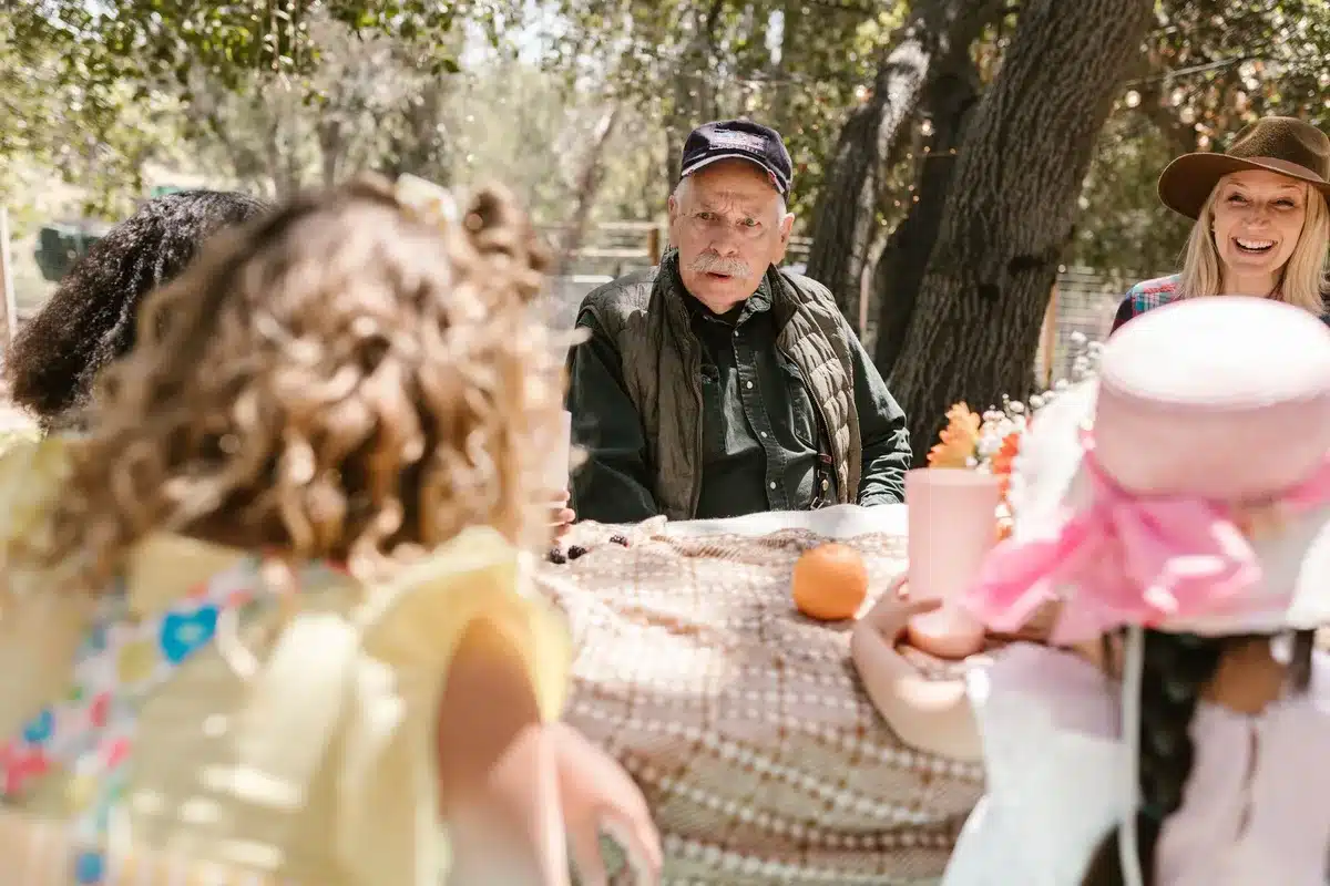 Abuelos y nietos conversando alrededor de una mesa en un ambiente familiar cálido