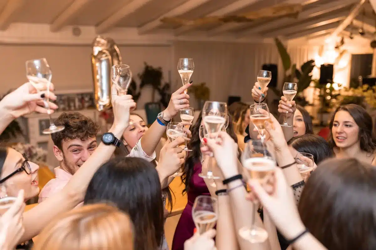Jóvenes en una reunión social, algunos rechazando bebidas alcohólicas con gestos relajados