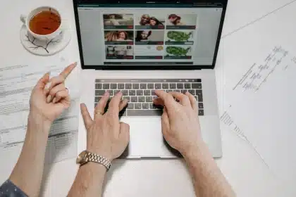 Manos organizando una tienda online en la pantalla de un ordenador portátil desde casa