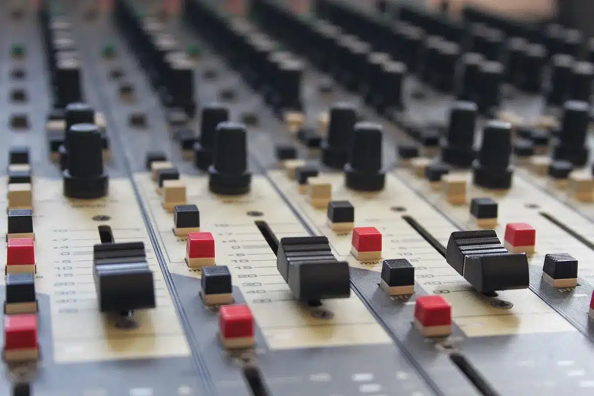 Técnico ajustando controles en una consola de mezcla profesional en un estudio de sonido