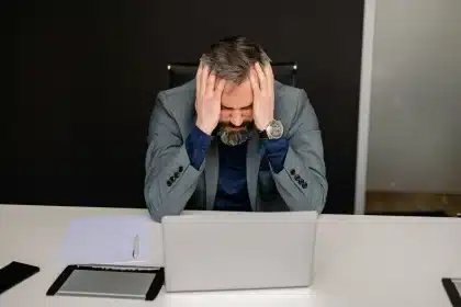 Joven profesional estresado en su escritorio, sintiéndose abrumado por el trabajo