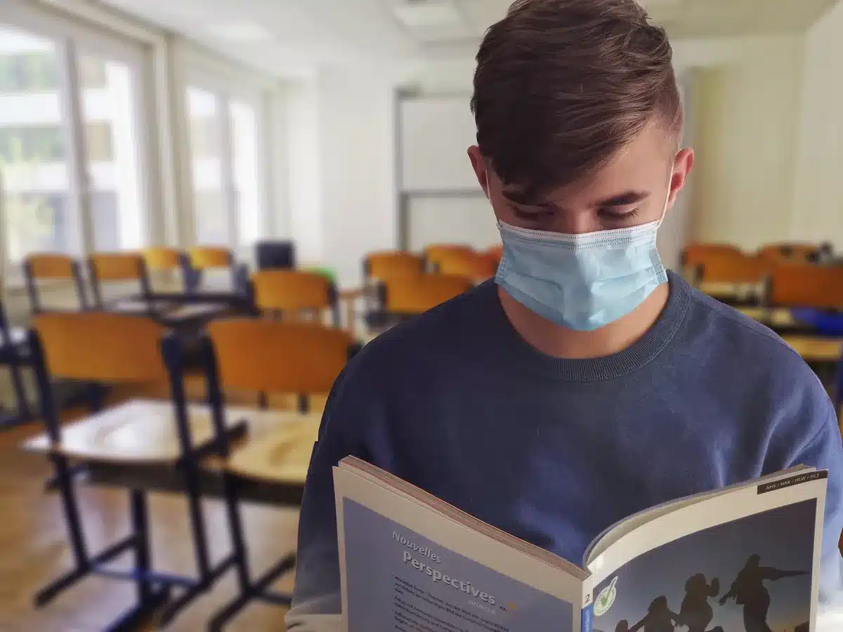 Escritorio de estudiante con libros, portátil y carta de aceptación universitaria
