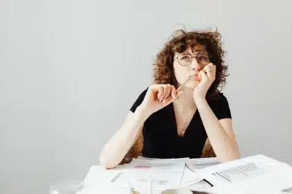 Joven adulto revisando documentos de formación en un escritorio iluminado