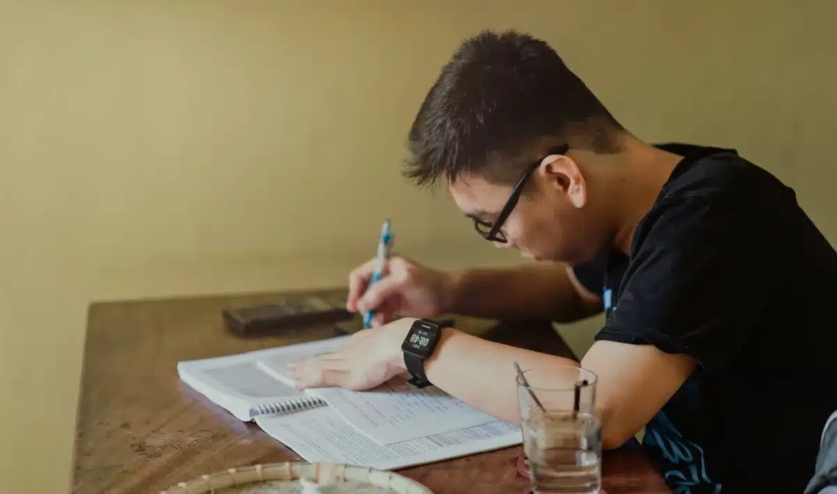 Persona adulta concentrada en el aprendizaje con materiales de estudio