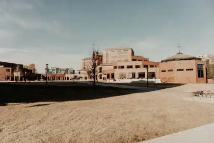 Campus universitario moderno con estudiantes e investigadores trabajando en espacios colaborativos