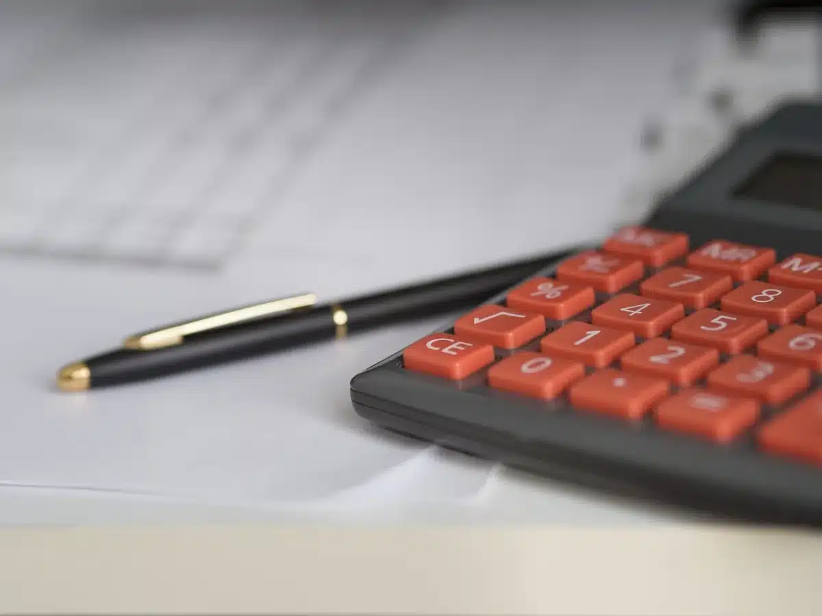 Escritorio de autónomo con facturas y calculadora ilustrando rendimientos netos