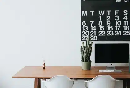Manos sobre facturas y calculadora con calendario marcado en trimestres