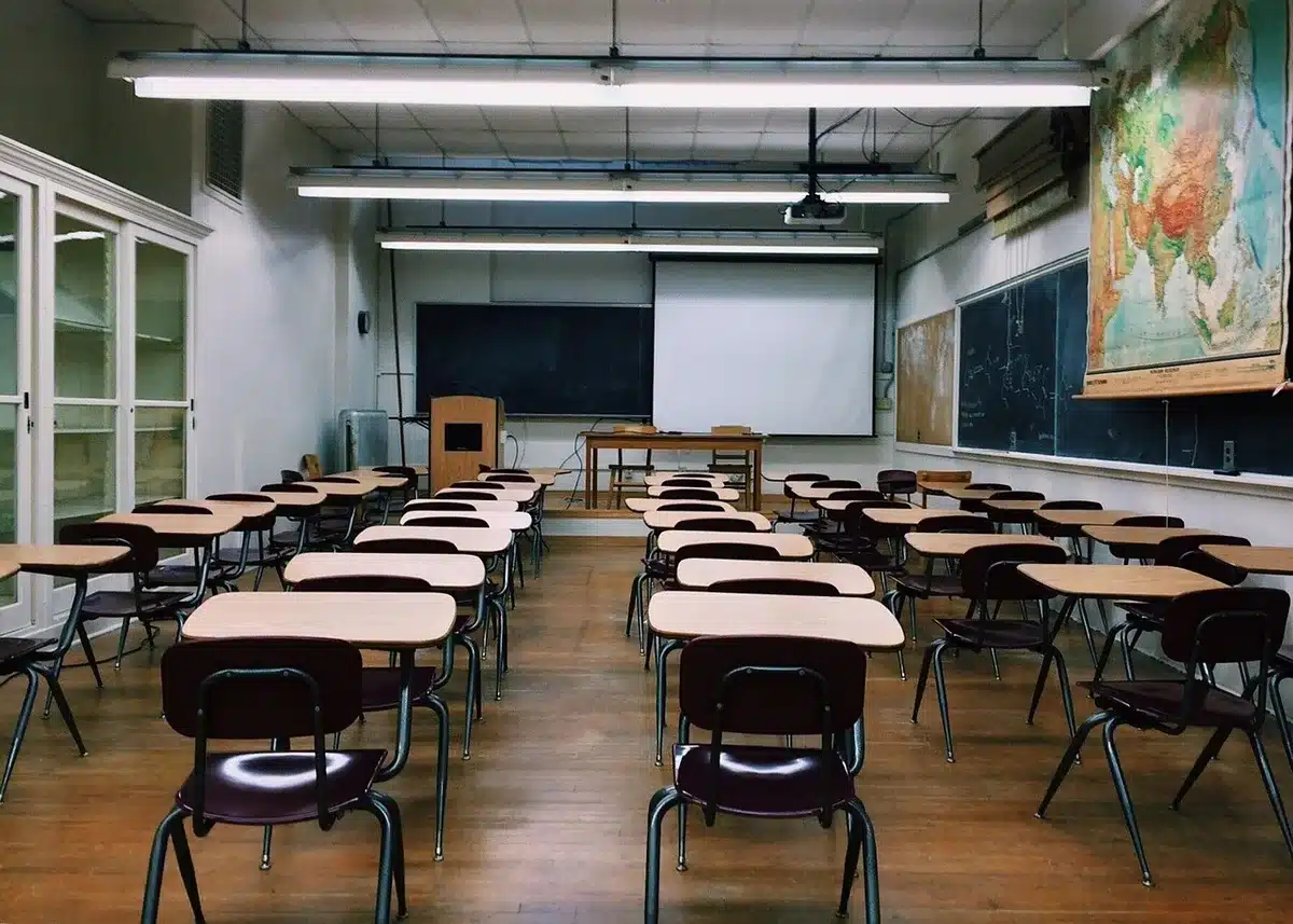 Aula moderna y multicultural con estudiantes y docentes trabajando colaborativamente en un entorno internacional.