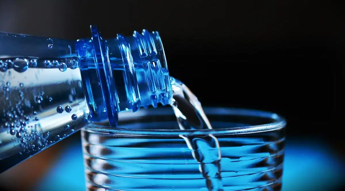 Repartidores reunidos con botellas de agua y camisetas en una protesta