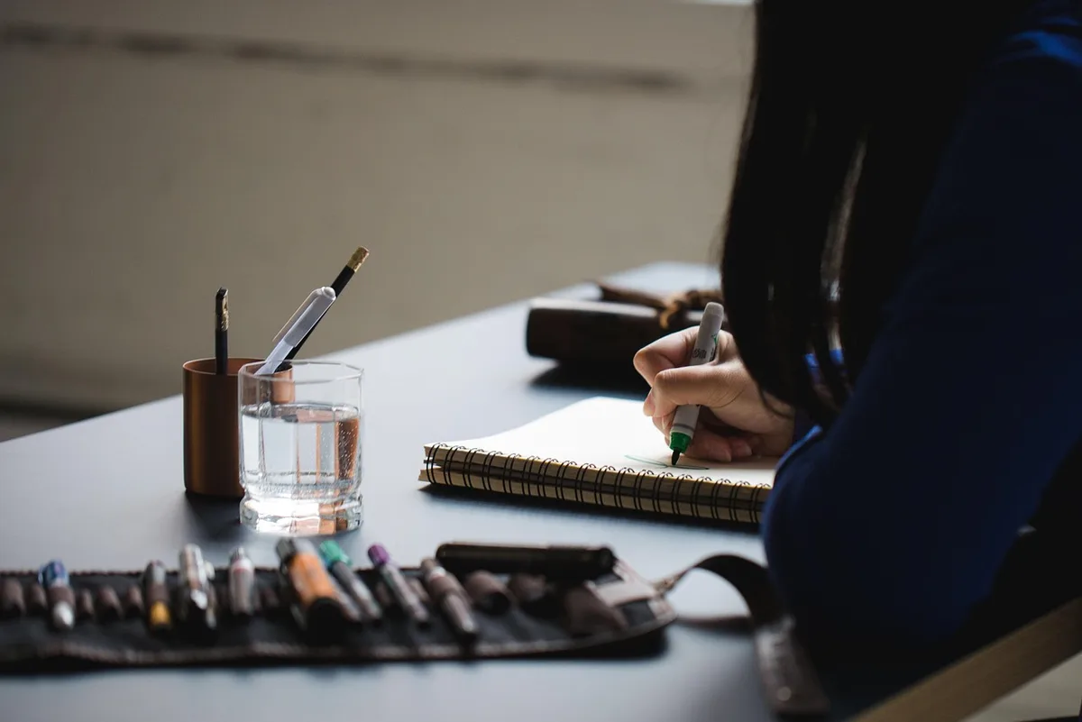 Cuaderno abierto con notas y bolígrafo para escritura creativa