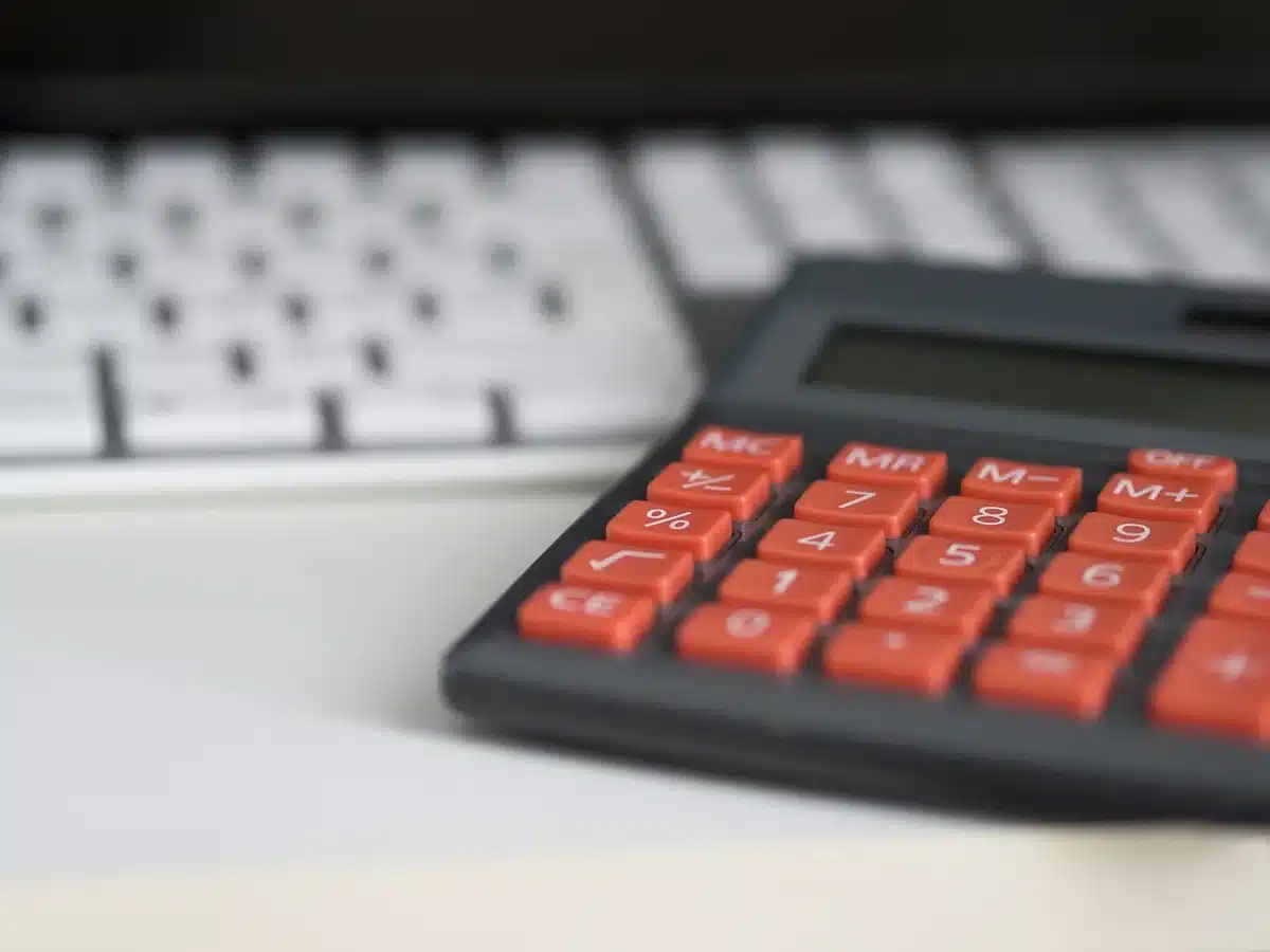 Calculadora y papeles con cifras que ilustran el cálculo de la cuota por días