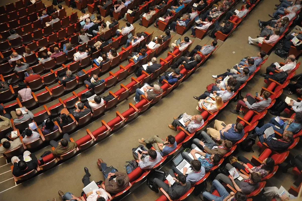 Asamblea de docentes con folletos y pancartas apiladas sobre una mesa