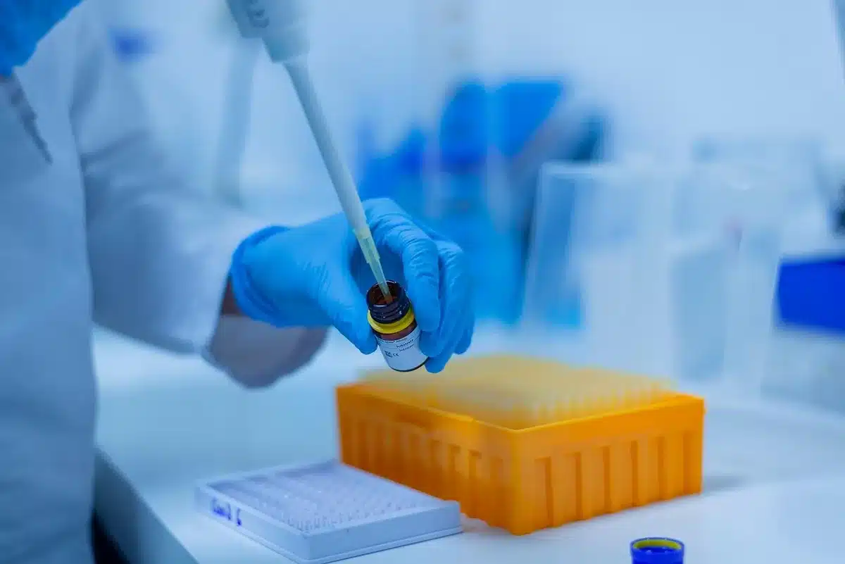 Técnico de laboratorio manejando muestras y equipo en un laboratorio clínico