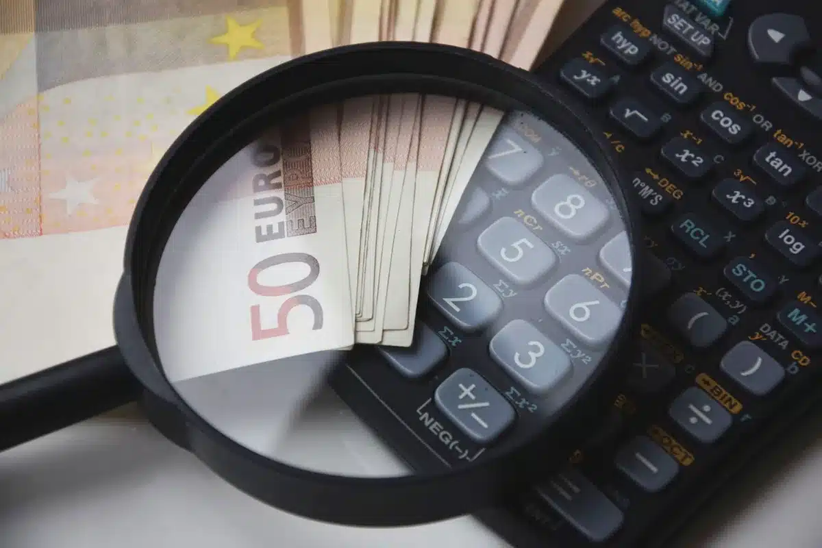 Factura con cifras, calculadora y anotaciones del IVA en una mesa