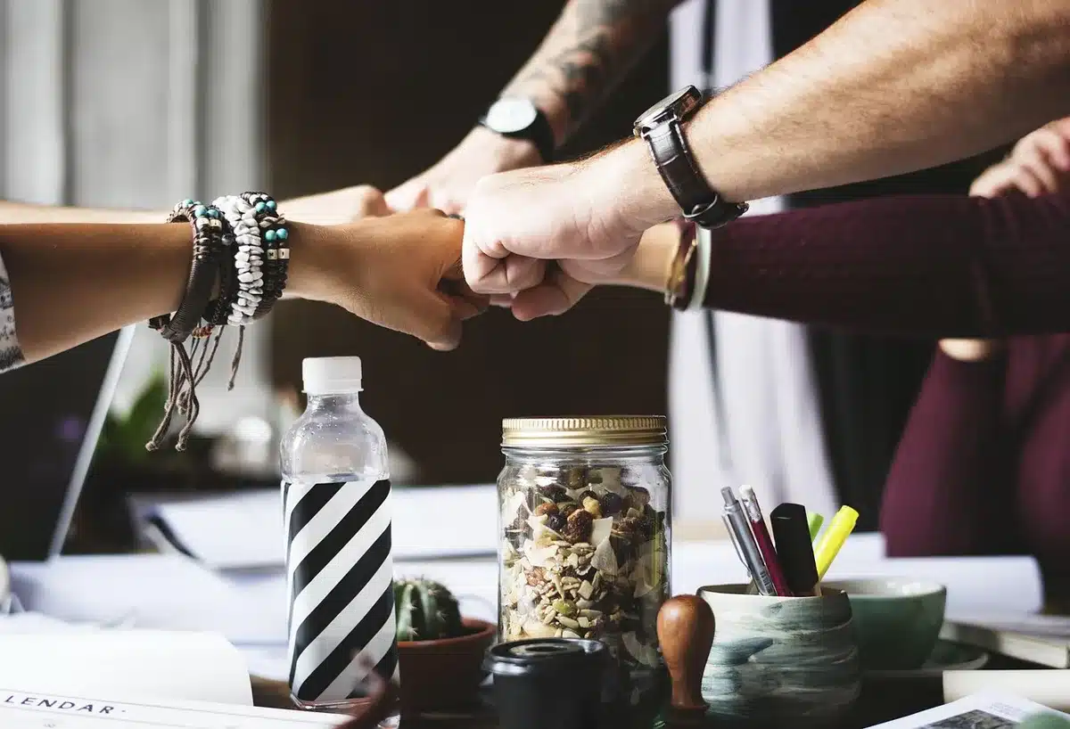 Mesa de reunión con portátiles, un pequeño rack y planos que sugieren proyectos de IA