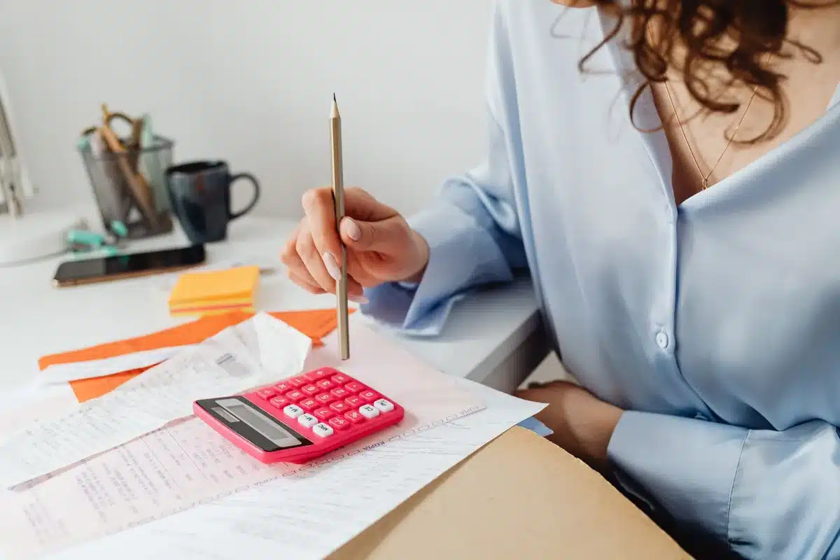 Manos calculando presupuesto familiar con papeles y calculadora