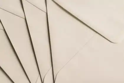 Sobres y una notificación en un escritorio con una mano en sombra