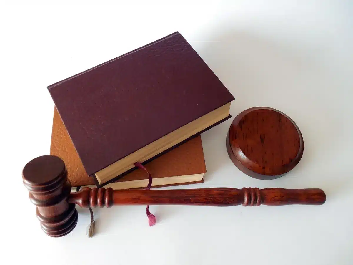 Libro de leyes y mazo que representan el choque entre normativa y derechos educativos