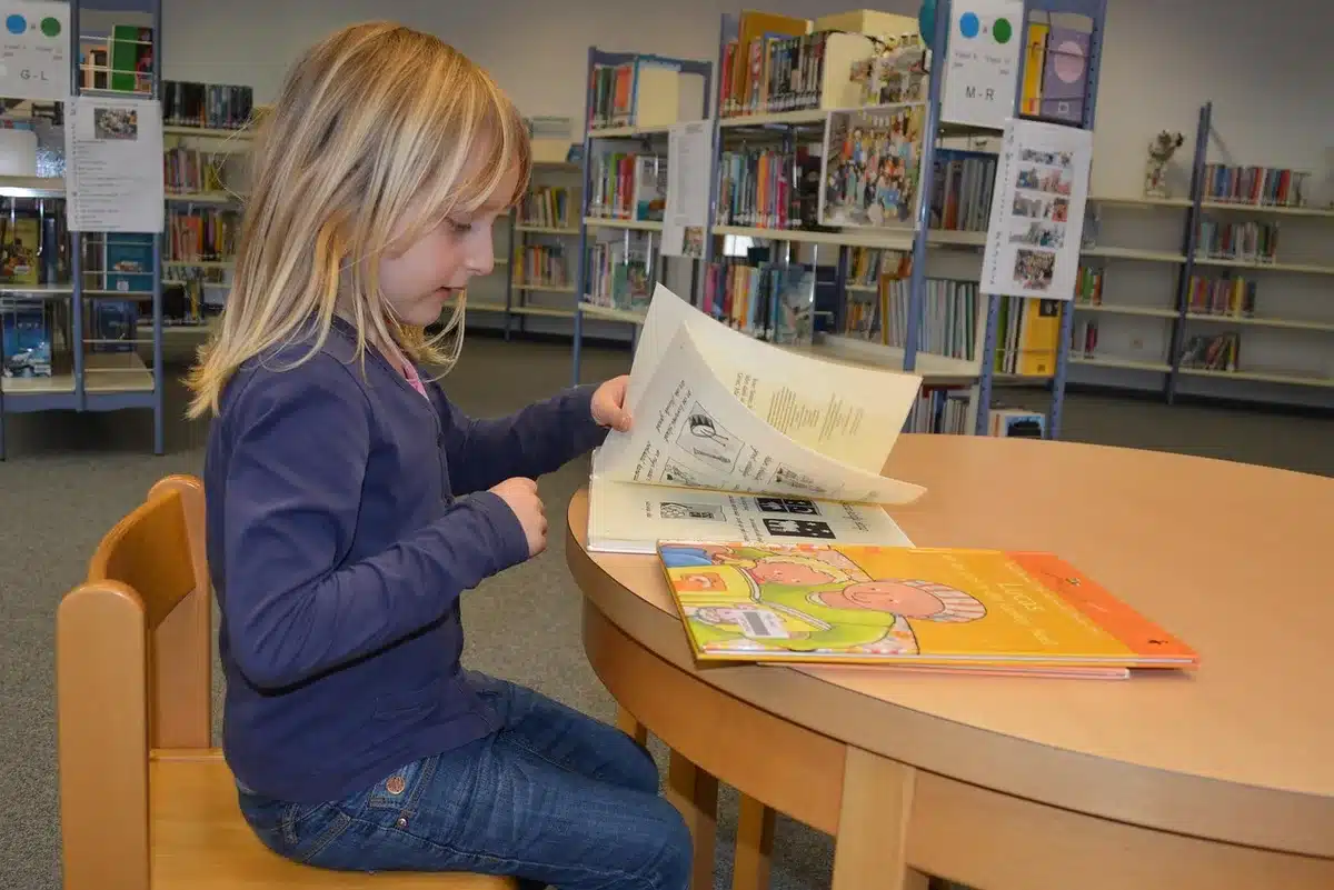 Alumnos en una biblioteca escolar leyendo juntos