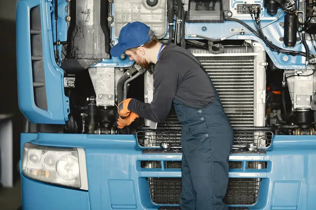 Técnico junto a un brazo robótico programable en un taller industrial