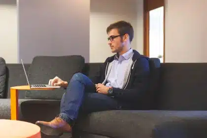 Mesa de trabajo con portátil mostrando una hoja de cálculo y manos anotando cifras