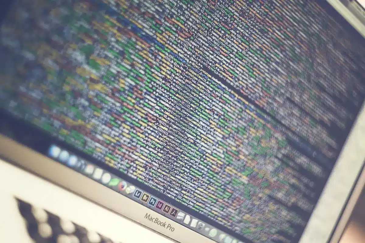 Persona programando en un portátil mostrando código HTML y CSS
