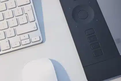 Mano anónima con facturas en papel y tablet sobre mesa de oficina