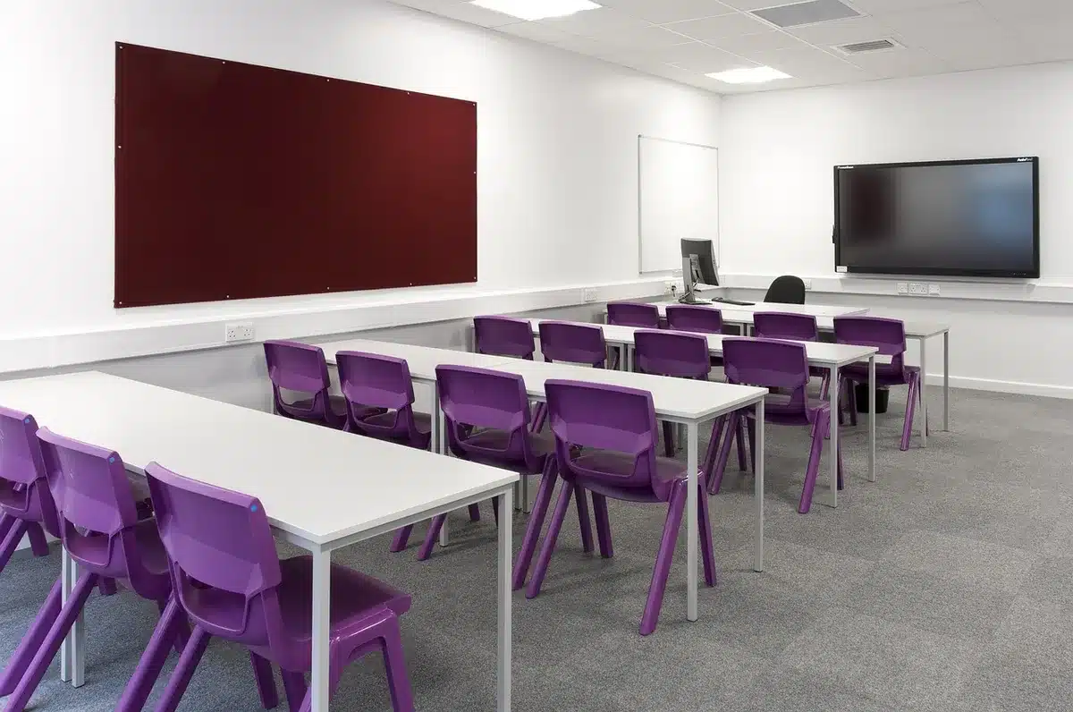 Aula universitaria vacía y documentación presupuestaria sobre una mesa