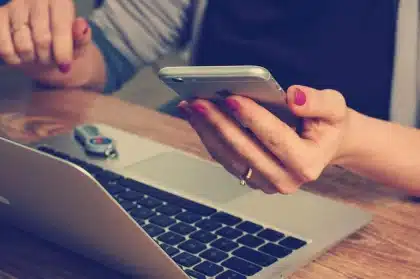 Manos revisando facturas y calendario sobre mesa de trabajo, simbolizando gestión del IVA mensual