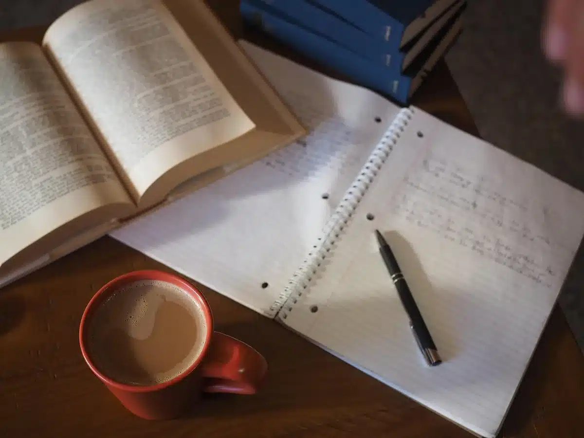 Estudiante con libros y apuntes en un escritorio, estudiando en casa